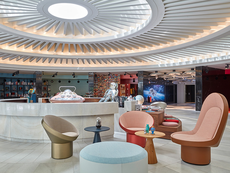 A large circular hotel lobby area with futuristic furniture and ceiling