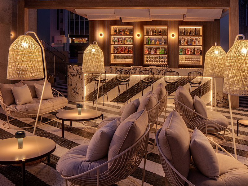 Lounge chairs in a bar which has striking black and white striped flooring