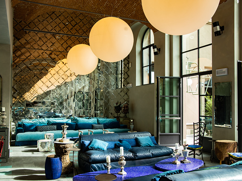 Large circular ceiling lights above a seating area with doors leading out to a terrace