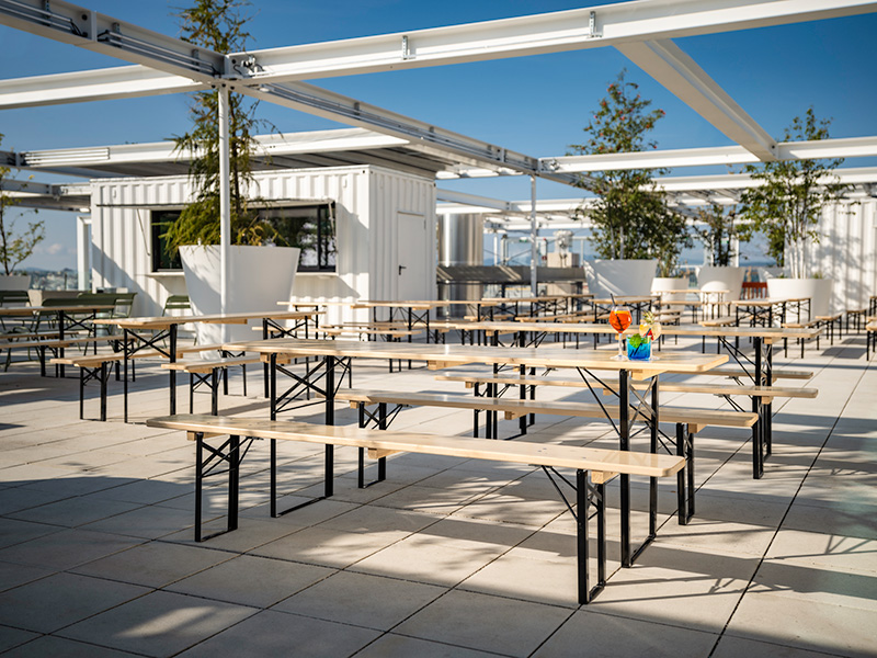 Large tables and benches designed for groups of people in an outside terrace