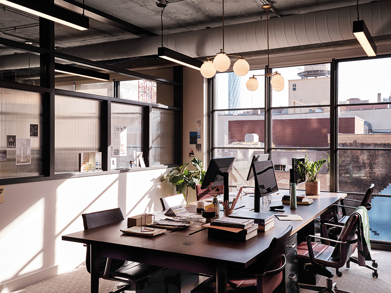 Small studio office for size people with floor to ceiling windows.