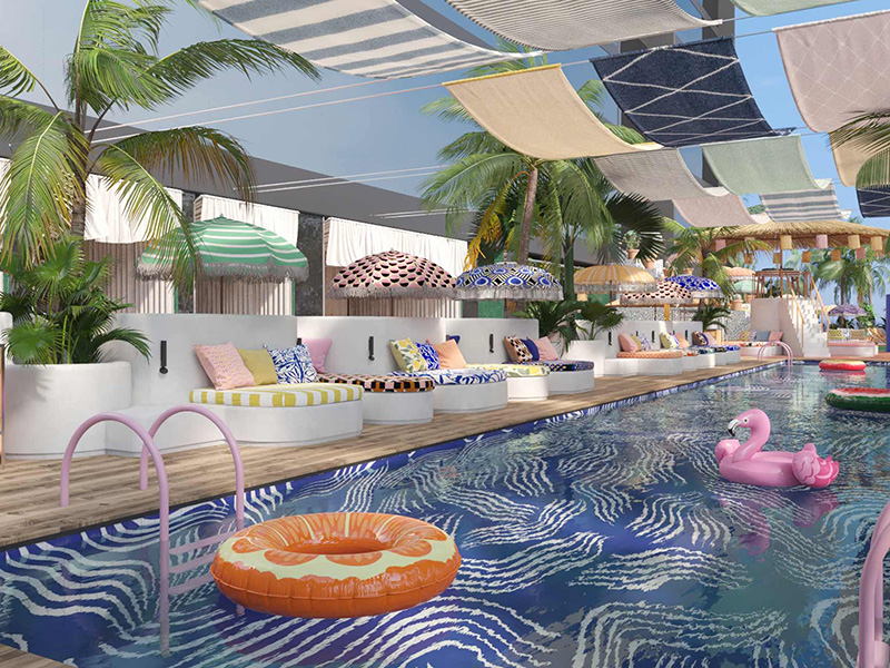 A pool with circular and Flamingo floats. Sun-beds, umbrellas and palm trees line the edge.